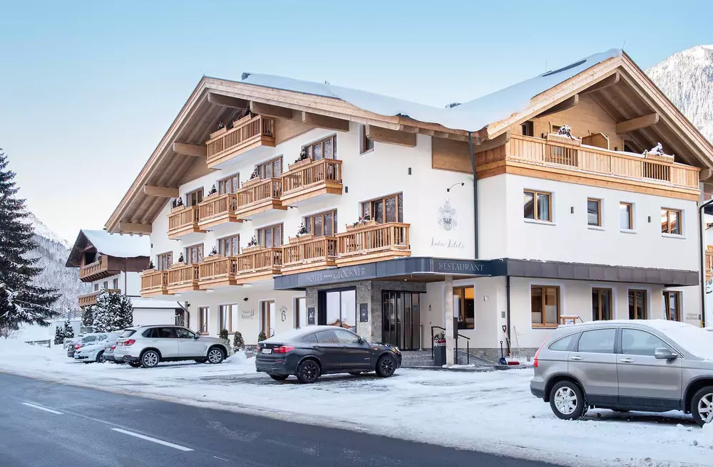 Fassade und Parkplatz des Hotel Glöckner im Winter bei Neuschnee und Sonnenschein